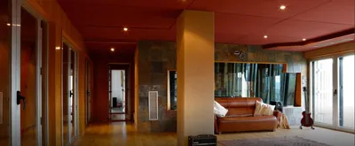 Live room with a leather sofa, red electric guitar and a corridor of glass booths