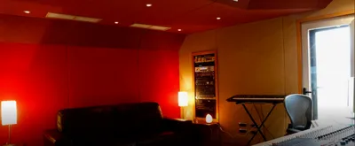 Control room with a red wall, leather sofa, outboard rack and keyboard