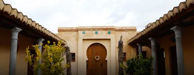 Colonnaded courtyard leading to a wooden horseshoe-arched door